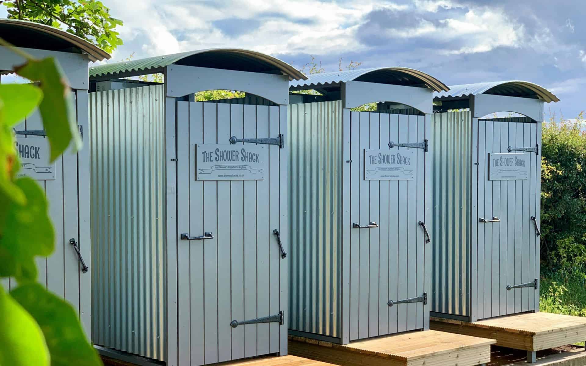 Outdoor farm shower cabins at Barn Drift Norfolk, ideal for rural holiday stays.