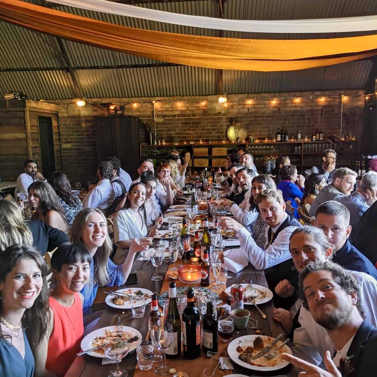 Enjoying a lively group dinner at The Hanger, Barn Drift Norfolk, with friends and family in a rusti.