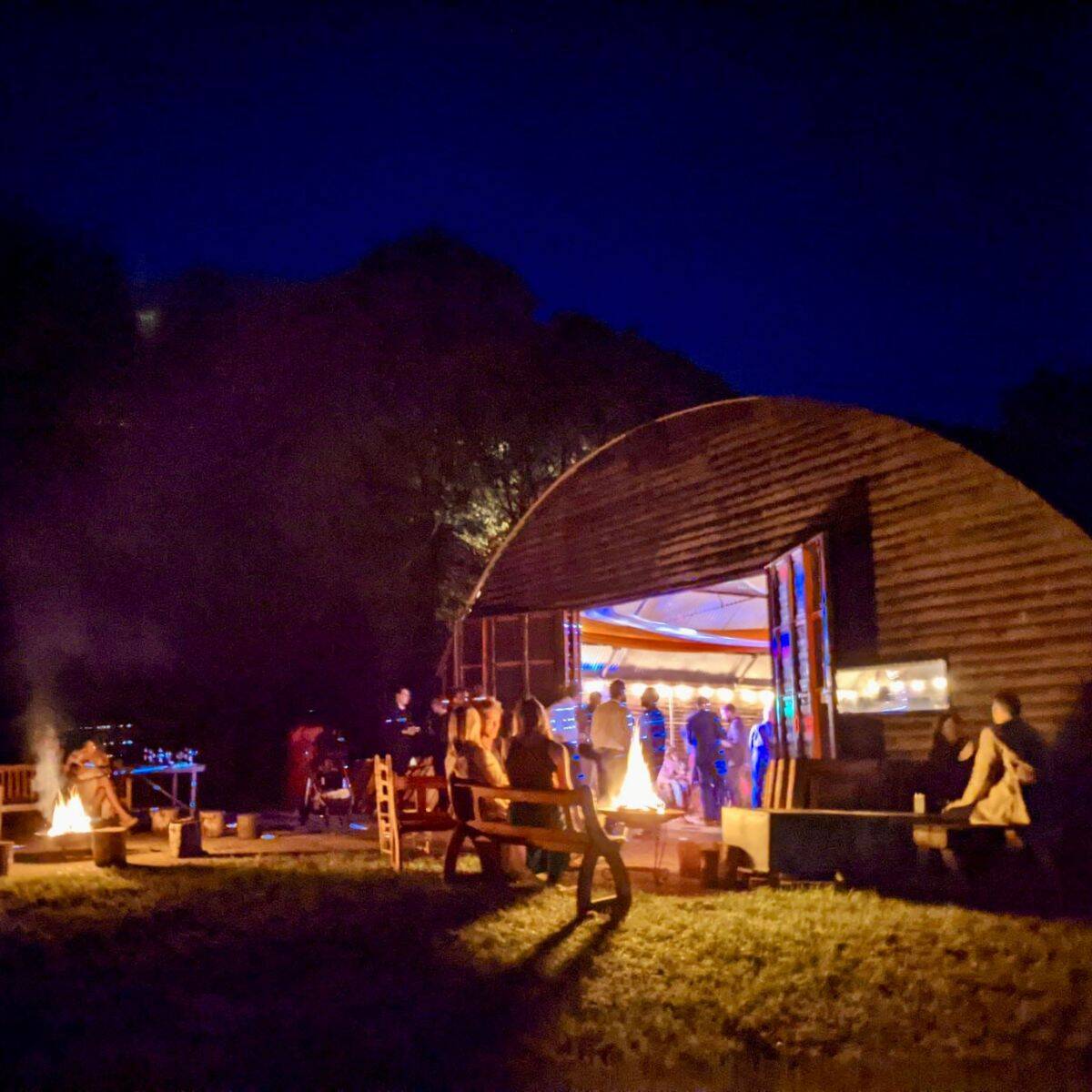 Barn Drift Norfolk at night with outdoor seating and illuminated barn structure.