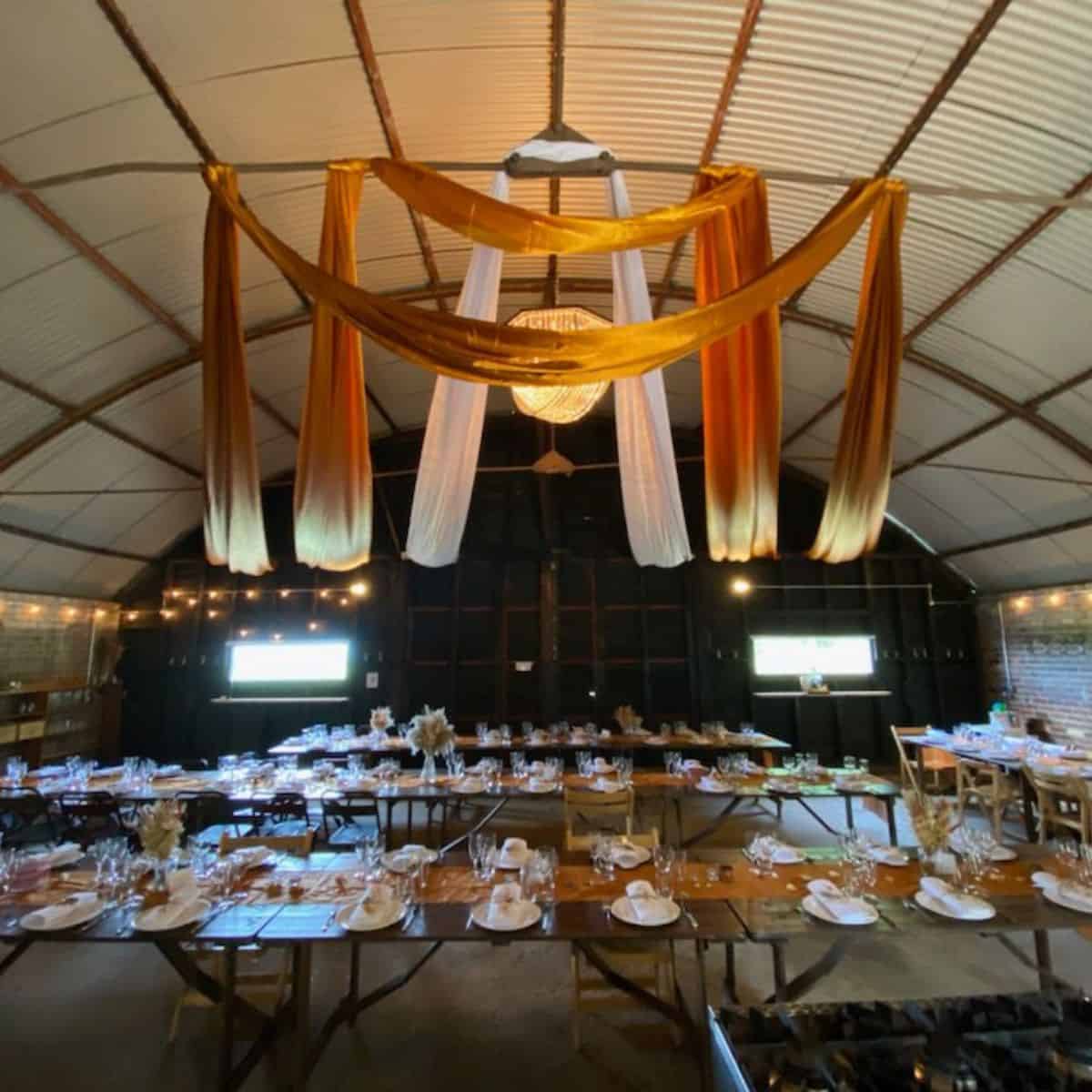 Elegant barn wedding reception setup with draped fabric and warm lighting in Norfolk.