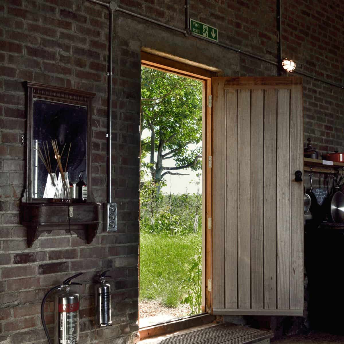 Rustic barn door open to Norfolk countryside at The Hanger, Barn Drift, Norfolk.