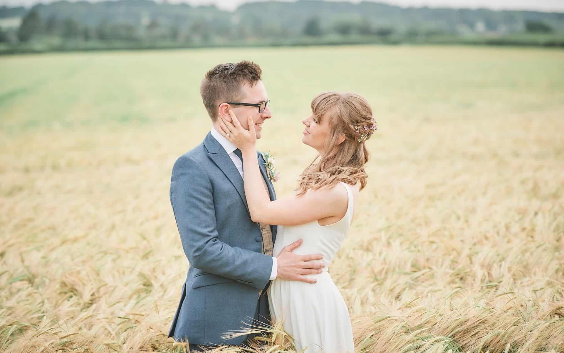 A couple embracing in a field at Barn Drift, Norfolk, perfect for small wedding venues.