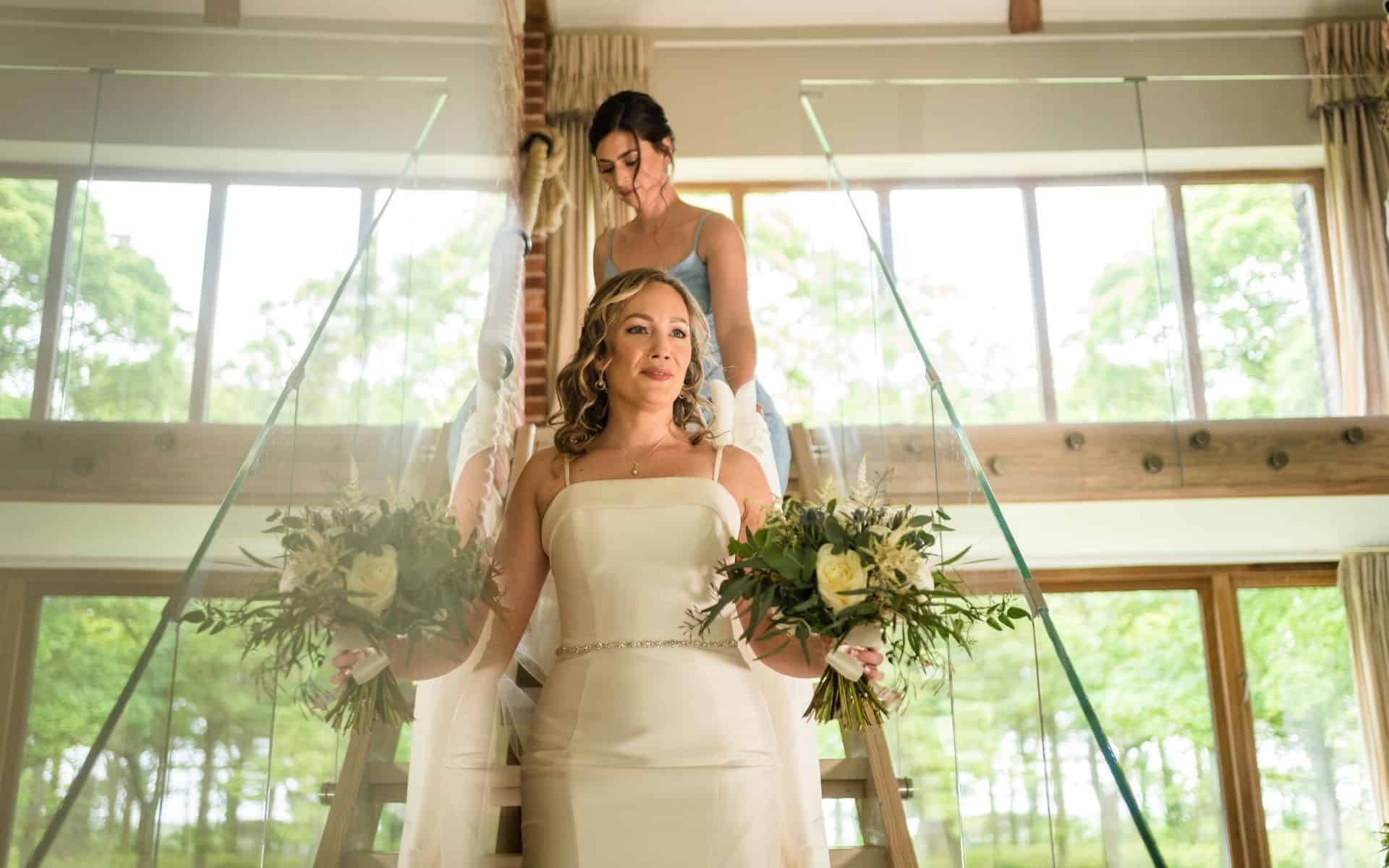 Elegant bride holding floral bouquets at Barn Drift Norfolk wedding venue.