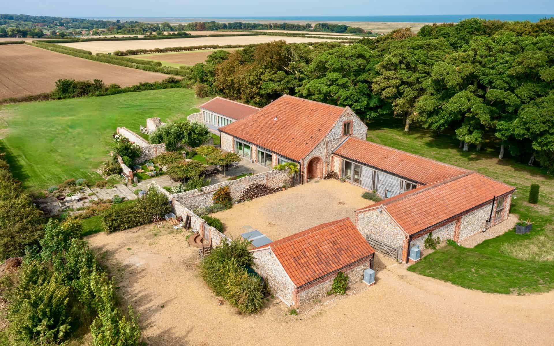 harming Norfolk woodland wedding venue with rustic stone buildings, perfect for outdoor ceremonies.